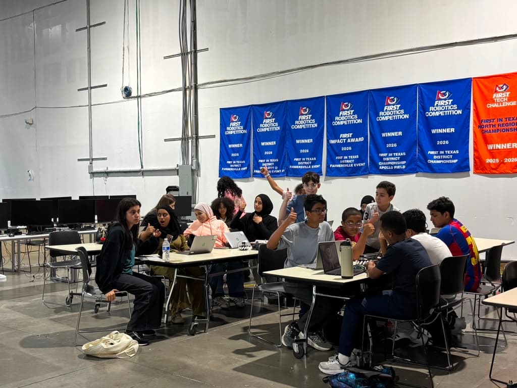 ITKAN students gather for a training session beneath the team's banner wall