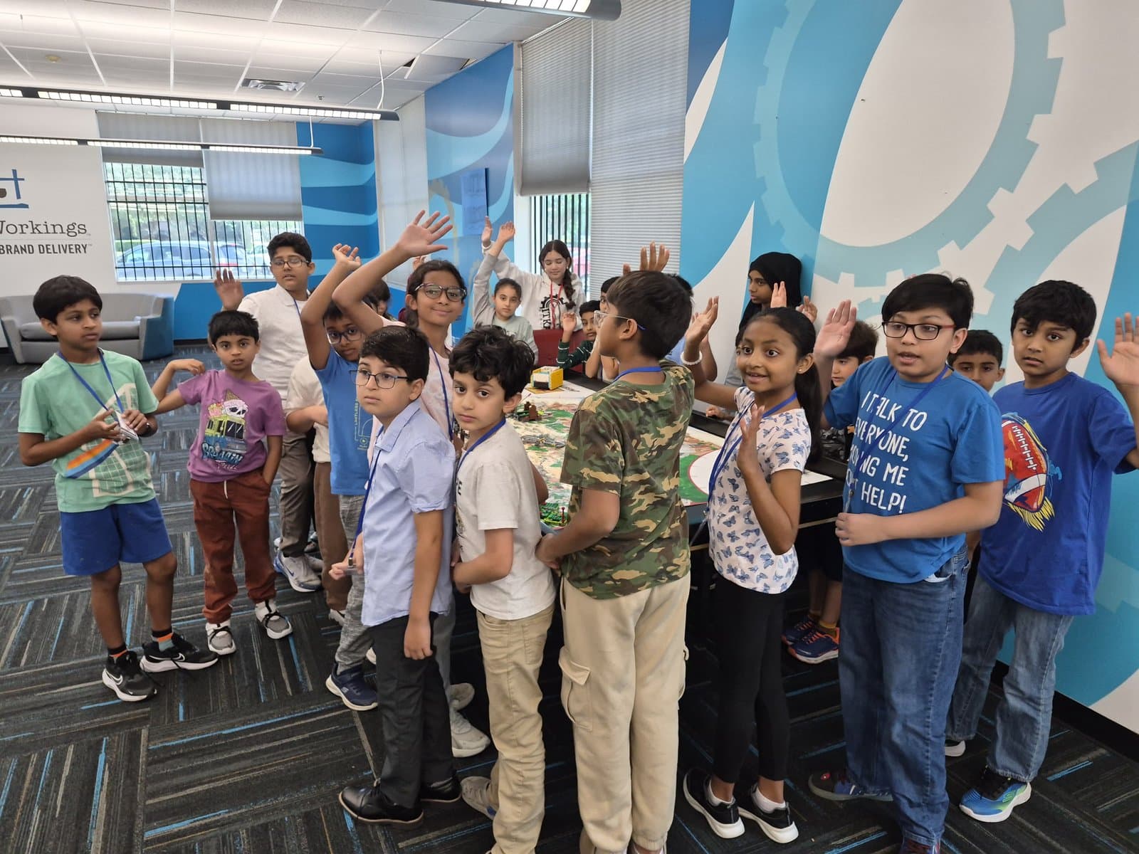 ITKAN students raise their hands with energy on the first day of the FLL Summer Training Program
